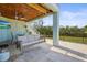 Beautifully appointed covered patio with a swing, fan, dining set, and access to the backyard at 4109 Cobia Ct, Palmetto, FL 34221