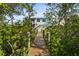 Exterior view of home framed by trees and a wood path leading to the home with balcony at 4109 Cobia Ct, Palmetto, FL 34221