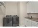Functional laundry room with modern washer and dryer, paired with a utility sink and white cabinets at 4109 Cobia Ct, Palmetto, FL 34221