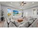 Bright living room features a large gray sectional, light wood floors, TV, and neutral decor at 4109 Cobia Ct, Palmetto, FL 34221