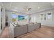 Spacious living room boasts a large sectional, light wood floors, and backyard views at 4109 Cobia Ct, Palmetto, FL 34221