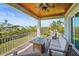 Covered porch with a lovely seating area and views of the landscape beyond the railing at 4109 Cobia Ct, Palmetto, FL 34221