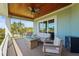 Outdoor seating area with a fire pit table on a covered porch with a lovely wooded view at 4109 Cobia Ct, Palmetto, FL 34221