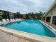 Large community swimming pool surrounded by lounge chairs with buildings in background at 425 30Th W Ave # C112, Bradenton, FL 34205