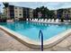 Large community swimming pool surrounded by lounge chairs with buildings in background at 425 30Th W Ave # C112, Bradenton, FL 34205