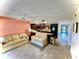 Bright living room with tile floors and ceiling fan, connected to kitchen, creating an inviting and seamless living space at 425 30Th W Ave # C112, Bradenton, FL 34205