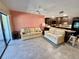 Open concept living room featuring tile flooring, a ceiling fan, and seamless access to the modern kitchen at 425 30Th W Ave # C112, Bradenton, FL 34205