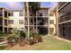 Exterior shot of the condo building with lush landscaping, plants, and lawn with views of the patio and balconies at 425 30Th W Ave # C208, Bradenton, FL 34205