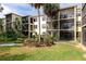 Exterior shot of the condo building with lush landscaping, plants, and lawn with views of the patio and balconies at 425 30Th W Ave # C208, Bradenton, FL 34205