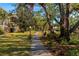 Beautifully landscaped community grounds with sidewalk, mature trees, and view of the building at 425 30Th W Ave # C208, Bradenton, FL 34205