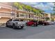 Exterior shot of condos with parking lot with several parked vehicles on a sunny day with palm trees at 425 30Th W Ave # C208, Bradenton, FL 34205