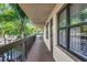 A condo walkway features mature trees, exterior lighting, and access to residential units, providing natural light at 425 30Th W Ave # C208, Bradenton, FL 34205