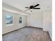 Cozy bedroom with two windows, a ceiling fan, and light wood-look floors at 425 Skylark Nw Ln, Port Charlotte, FL 33952