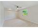 Spacious bedroom with a ceiling fan and a large window overlooking landscaping at 425 Skylark Nw Ln, Port Charlotte, FL 33952