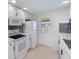 Well-lit kitchen featuring white cabinets, stainless steel appliances, and modern backsplash at 425 Skylark Nw Ln, Port Charlotte, FL 33952
