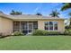 A well-maintained backyard featuring a spacious lawn, tropical landscaping, and a screened-in patio at 4250 Turnberry Cir, North Port, FL 34288