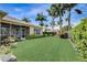 Expansive backyard with lush green lawn, tropical landscaping and the home's exterior at 4250 Turnberry Cir, North Port, FL 34288