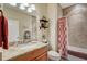 Bathroom featuring granite countertop, framed mirror, and tiled shower with decorative shower curtain at 4250 Turnberry Cir, North Port, FL 34288