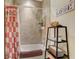 Cozy bathroom with tiled tub, decorative shower curtain, and shelving for storage and décor at 4250 Turnberry Cir, North Port, FL 34288