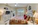 Bedroom with ceiling fan, television, and bed with decorative pillows and quilt, leading to patio at 4250 Turnberry Cir, North Port, FL 34288