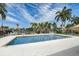 Community pool with seating, umbrellas, surrounded by lush landscaping and other community buildings at 4250 Turnberry Cir, North Port, FL 34288