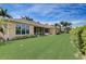 A well-kept lawn and tropical landscaping adorn this home exterior with screened lanai at 4250 Turnberry Cir, North Port, FL 34288