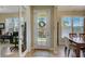 Welcoming foyer with a decorative glass front door, tile flooring, and bright windows, leading into the home's inviting spaces at 4250 Turnberry Cir, North Port, FL 34288