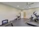 Brightly lit home gym featuring rubber flooring, weights, and cardio equipment at 4250 Turnberry Cir, North Port, FL 34288