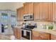 Charming kitchen with stainless steel appliances, granite countertops, and a view of the outdoor space at 4250 Turnberry Cir, North Port, FL 34288