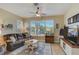 Inviting living room features tile floors, a ceiling fan, and large windows with plantation shutters at 4250 Turnberry Cir, North Port, FL 34288
