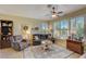 Comfortable living room with a plush sofa, recliner, area rug, and windows with plantation shutters at 4250 Turnberry Cir, North Port, FL 34288