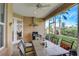 Relaxing patio featuring an outdoor grill, dining table with seating, and views of the serene backyard greenery at 4250 Turnberry Cir, North Port, FL 34288