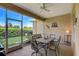 Covered patio with ceiling fan, dining table and chairs, and an outdoor grill for relaxing and entertaining at 4250 Turnberry Cir, North Port, FL 34288