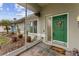 Inviting screened front porch with slate tile, green door, and lovely landscaping details add curb appeal at 4655 Payne St, North Port, FL 34287