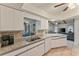 Open concept kitchen with granite countertops, white cabinets, tile backsplash, and stainless steel sink at 4655 Payne St, North Port, FL 34287
