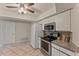 Bright kitchen featuring tile floors, white cabinets, stainless steel appliances, and granite countertops at 4655 Payne St, North Port, FL 34287