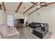Cozy living room with vaulted ceiling, wood beams, and large windows creates a warm space at 4655 Payne St, North Port, FL 34287