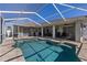 Large pool area featuring a screened-in pool and covered patio with ample seating at 4655 Payne St, North Port, FL 34287