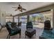 Enclosed pool area featuring comfortable seating, ceiling fans, and lush landscaping at 4655 Payne St, North Port, FL 34287