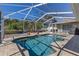 Beautiful pool area with covered and screened-in pool, surrounded by tropical landscaping at 4655 Payne St, North Port, FL 34287