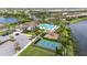An aerial shot shows the community's pool, clubhouse, parking, tennis court, and playground with a lake view at 4711 Cedron Ct, Sarasota, FL 34240