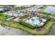 Overhead view showcases the community pool, tennis court, playground, clubhouse, and parking with lake views at 4711 Cedron Ct, Sarasota, FL 34240