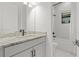 Bright bathroom features a granite countertop vanity and tiled shower-tub combination at 4711 Cedron Ct, Sarasota, FL 34240