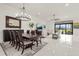 Open-concept dining and living room with modern lighting and a view of the screened lanai at 4711 Cedron Ct, Sarasota, FL 34240