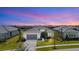 Beautiful one-story home with a gray roof, gray garage door, and tropical landscaping at sunset at 4711 Cedron Ct, Sarasota, FL 34240