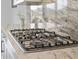 Close-up of a modern gas cooktop with sleek stainless steel burners and a marble countertop at 4711 Cedron Ct, Sarasota, FL 34240