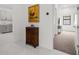 Inviting hallway featuring tile flooring and an ornate cabinet topped with art at 4711 Cedron Ct, Sarasota, FL 34240