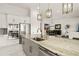 Stylish kitchen with a marble island, pendant lighting, and stainless steel appliances, open to dining area at 4711 Cedron Ct, Sarasota, FL 34240