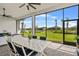 Screened lanai with a dining area, offering tranquil views of the pond and backyard at 4711 Cedron Ct, Sarasota, FL 34240