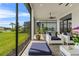 Relaxing screened lanai with plush seating overlooking a manicured lawn and pond at 4711 Cedron Ct, Sarasota, FL 34240